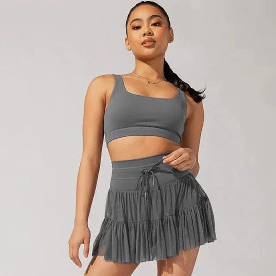A stylish high-waist lace-up sports skirt with built-in safety shorts in a variety of vibrant colors.