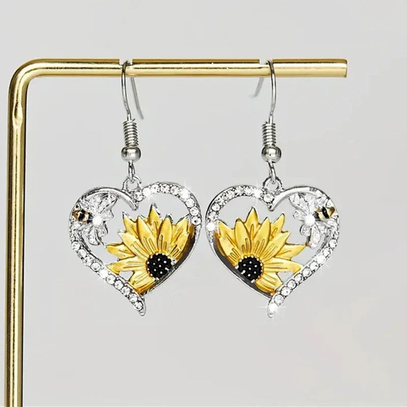 Elegant silver earrings featuring delicate bee and sunflower motifs, a stunning fashion accessory with natural charm.
