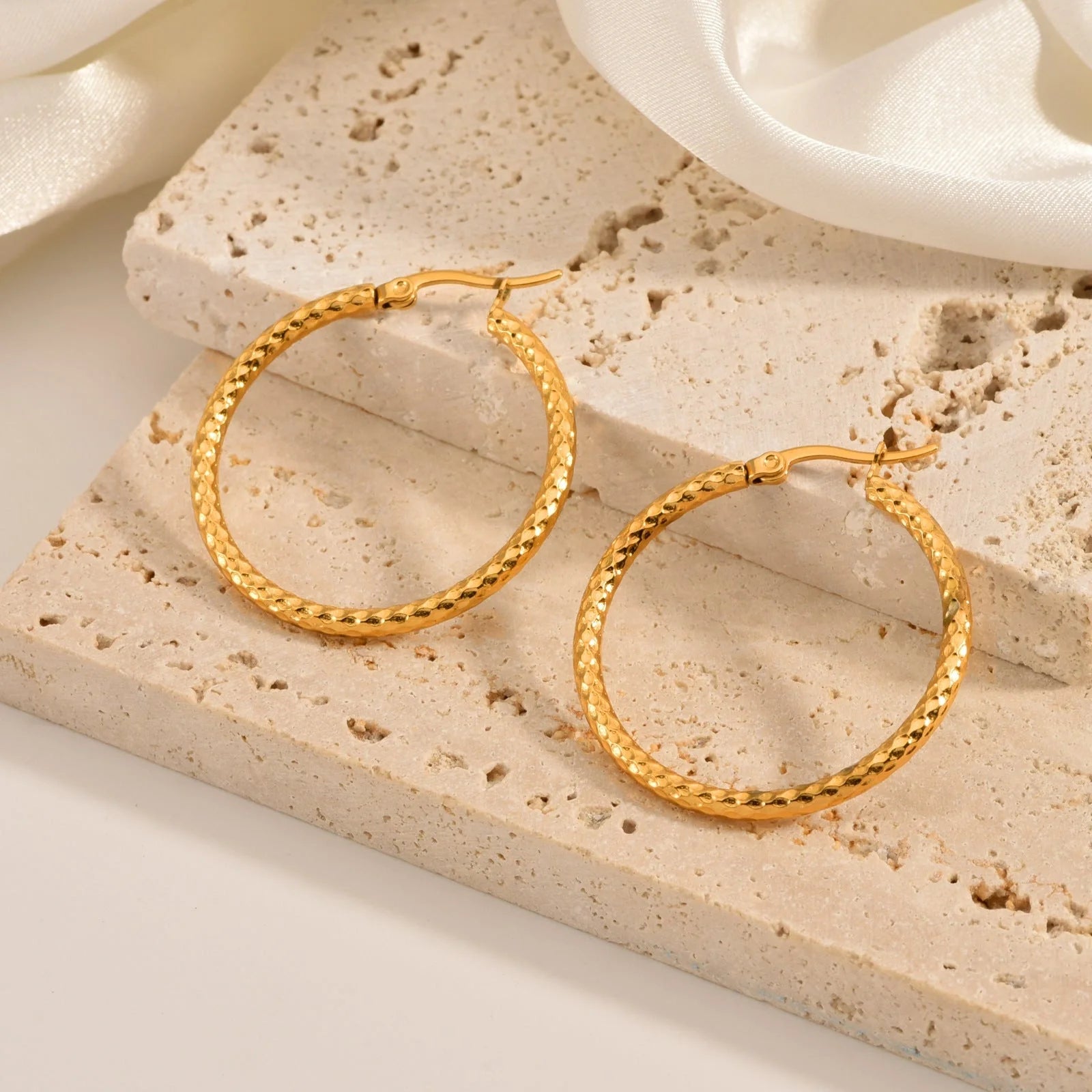 Elegant 18K gold-plated round ring earrings with embossed detail, perfect for any occasion.