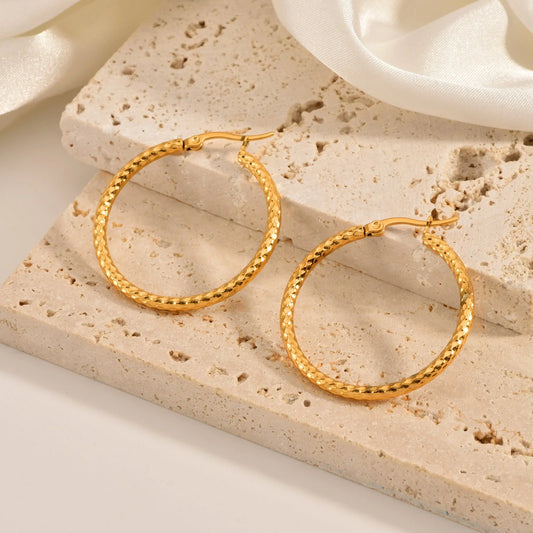 Elegant 18K gold-plated round ring earrings with embossed detail, perfect for any occasion.