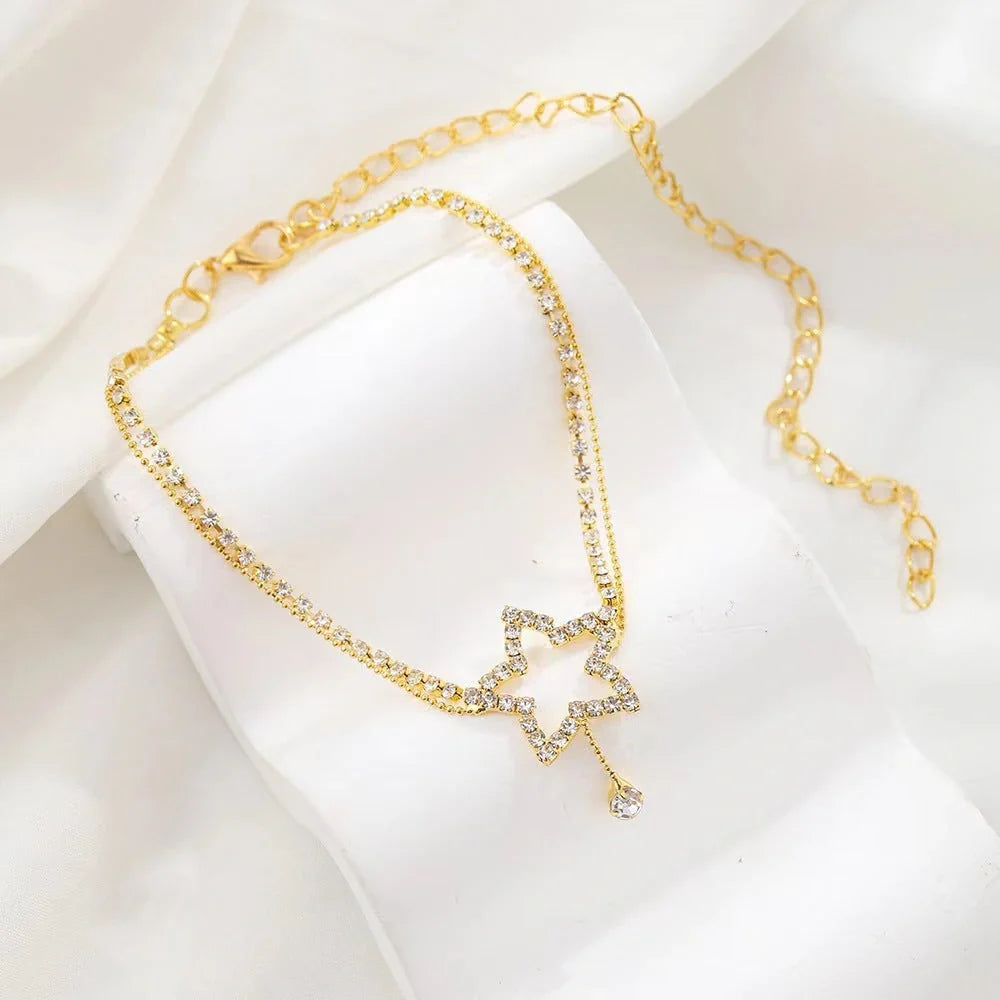 Sparkling star-shaped rhinestone necklace and anklet jewellery set in gold and silver tones