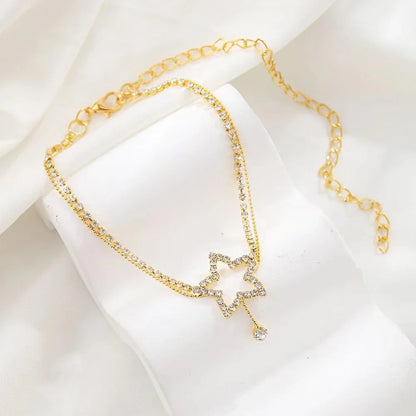 Sparkling star-shaped rhinestone necklace and anklet jewellery set in gold and silver tones