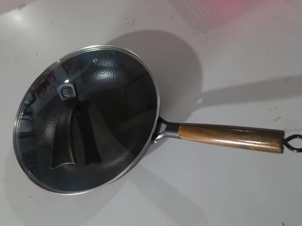Traditional handmade iron wok with wooden handle and lid