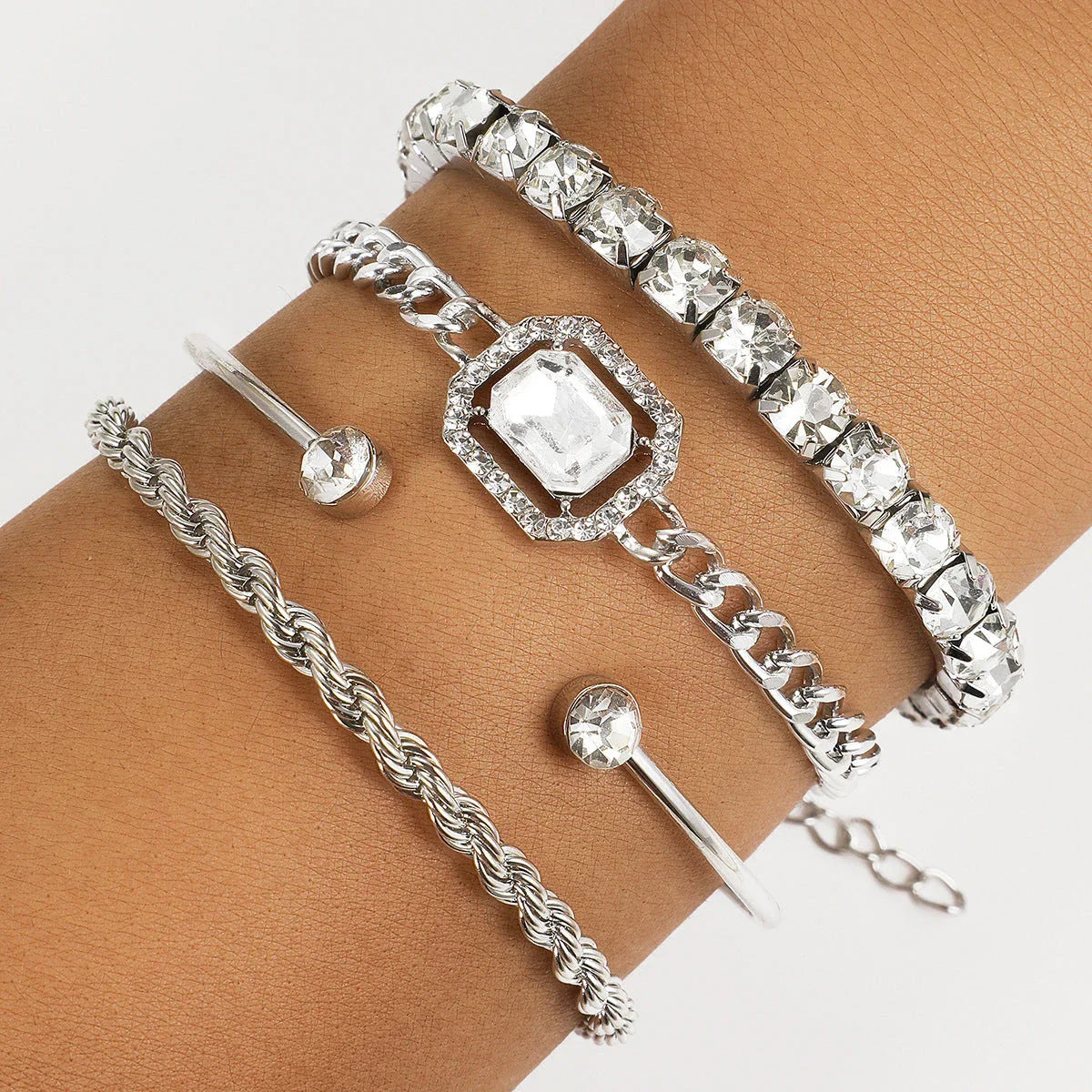 A set of four elegant crystal bracelets with vintage-inspired twisted cuff chains and sparkling rhinestones, perfect for adding a touch of luxury to any outfit.