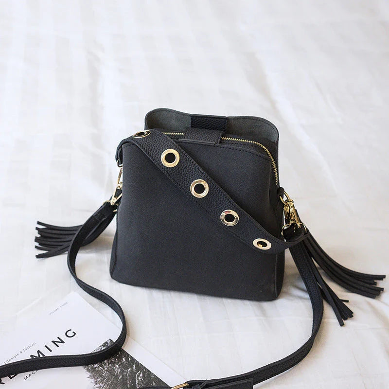 Trendy frosted tassel bucket bag in a range of classic colors, featuring a spacious interior and a dedicated camera pocket for maximum convenience.