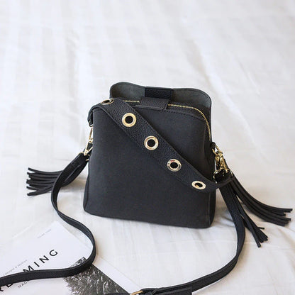 Trendy frosted tassel bucket bag in a range of classic colors, featuring a spacious interior and a dedicated camera pocket for maximum convenience.