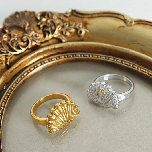 Ocean Style Scallop Ring in titanium steel and gold finishes, showcasing geometric design inspired by the sea.