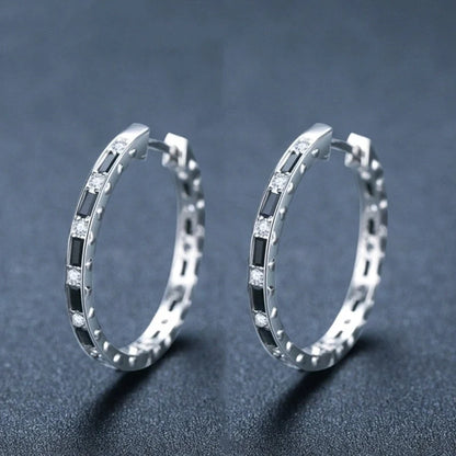 A pair of elegant black zircon earrings with a round, geometric design made of premium copper