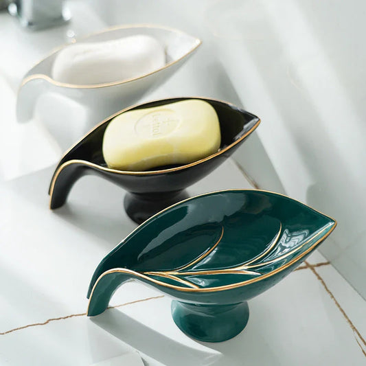 Elegant ceramic soap dish with leaf-shaped design, suction cup base, and drainage holes for bathroom storage and decor