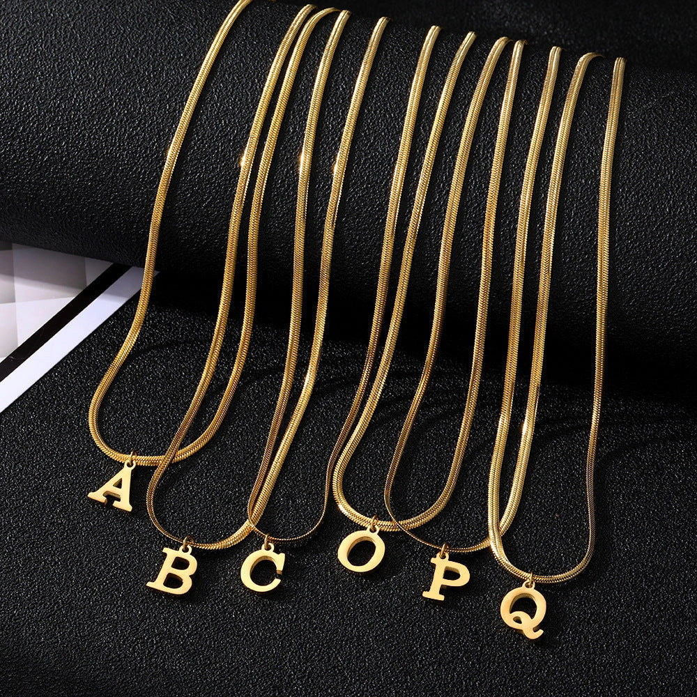 Gold-coloured A-Z letter pendant necklace on a snake chain