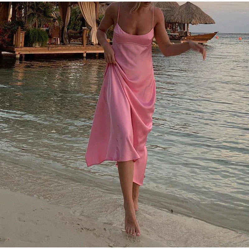 A sleek and elegant satin slip dress in a stunning pink color with a backless design and full-length silhouette.
