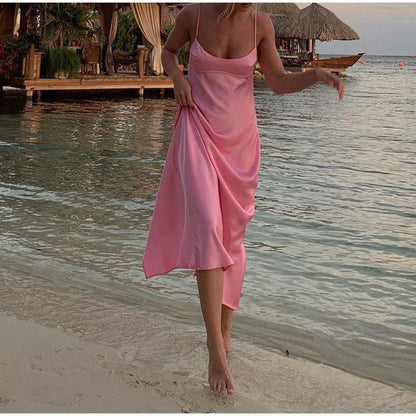 A sleek and elegant satin slip dress in a stunning pink color with a backless design and full-length silhouette.