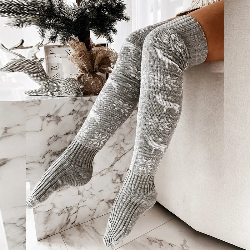 Cozy Christmas knee-high socks for women featuring a festive snowflake and reindeer pattern, designed to provide warmth and comfort during the winter season.