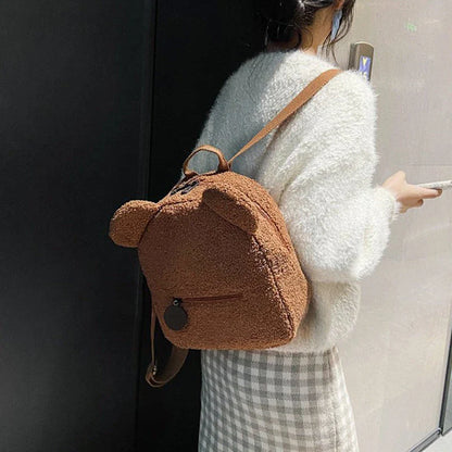 Adorable bear-shaped backpack made of soft fleece material in various colors, featuring a spacious main compartment and adjustable shoulder straps for comfortable wear.