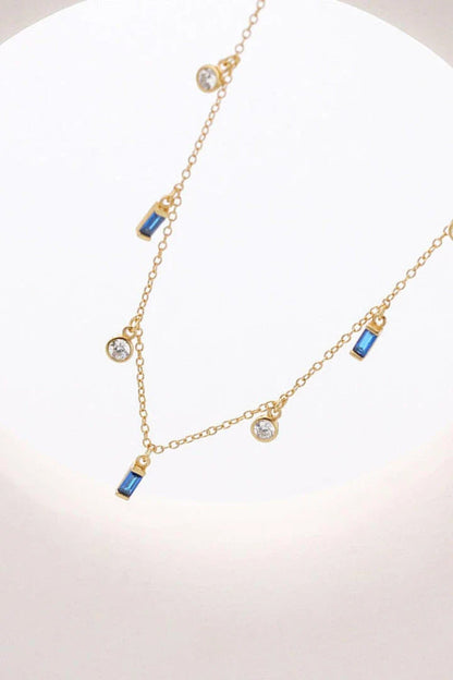 Elegant 18K gold-plated multi-charm chain necklace with delicate charms and a minimalist design