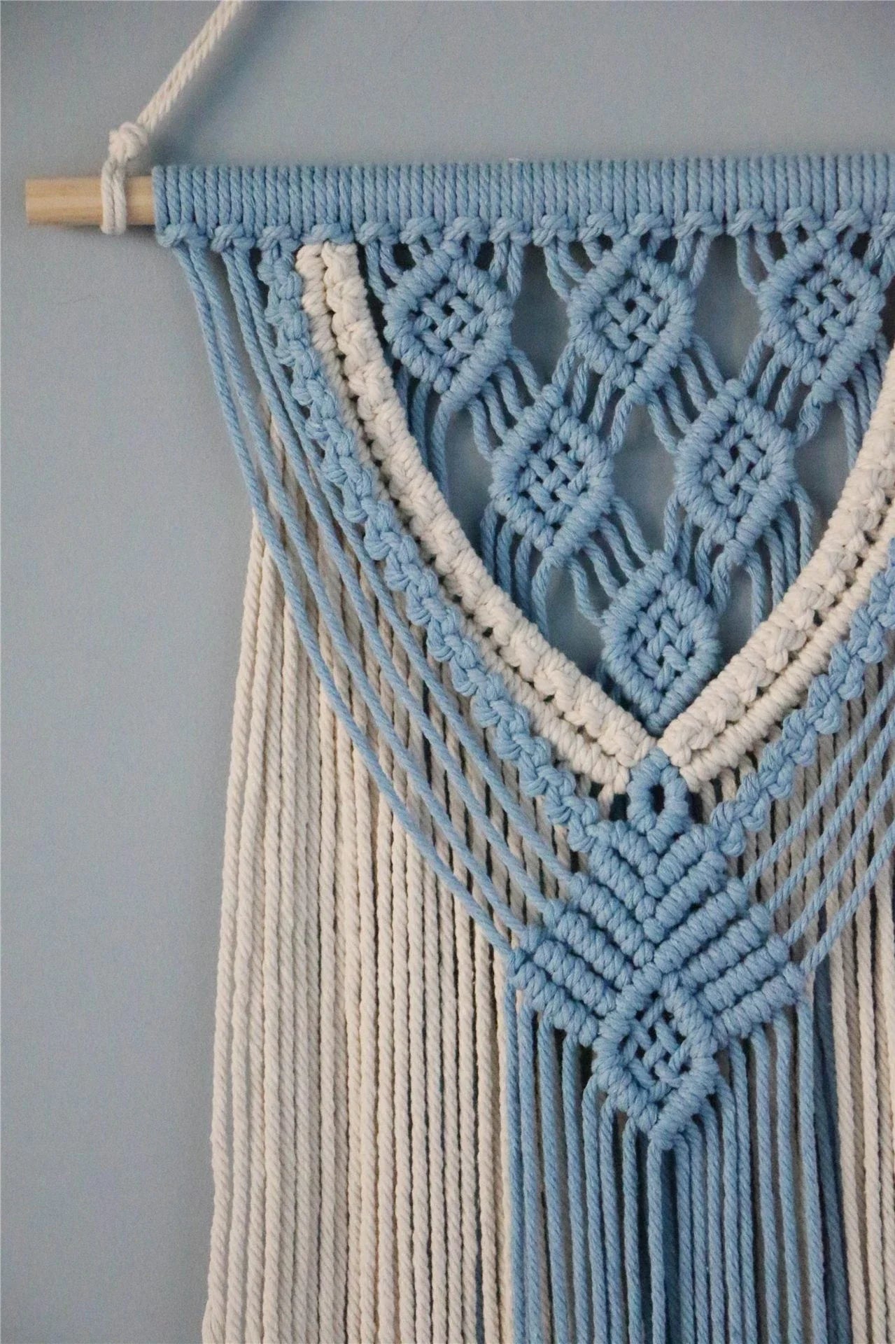 Hand-woven cotton string tapestry with blue and white colours, featuring playful tassels for a modern and rustic wall decoration