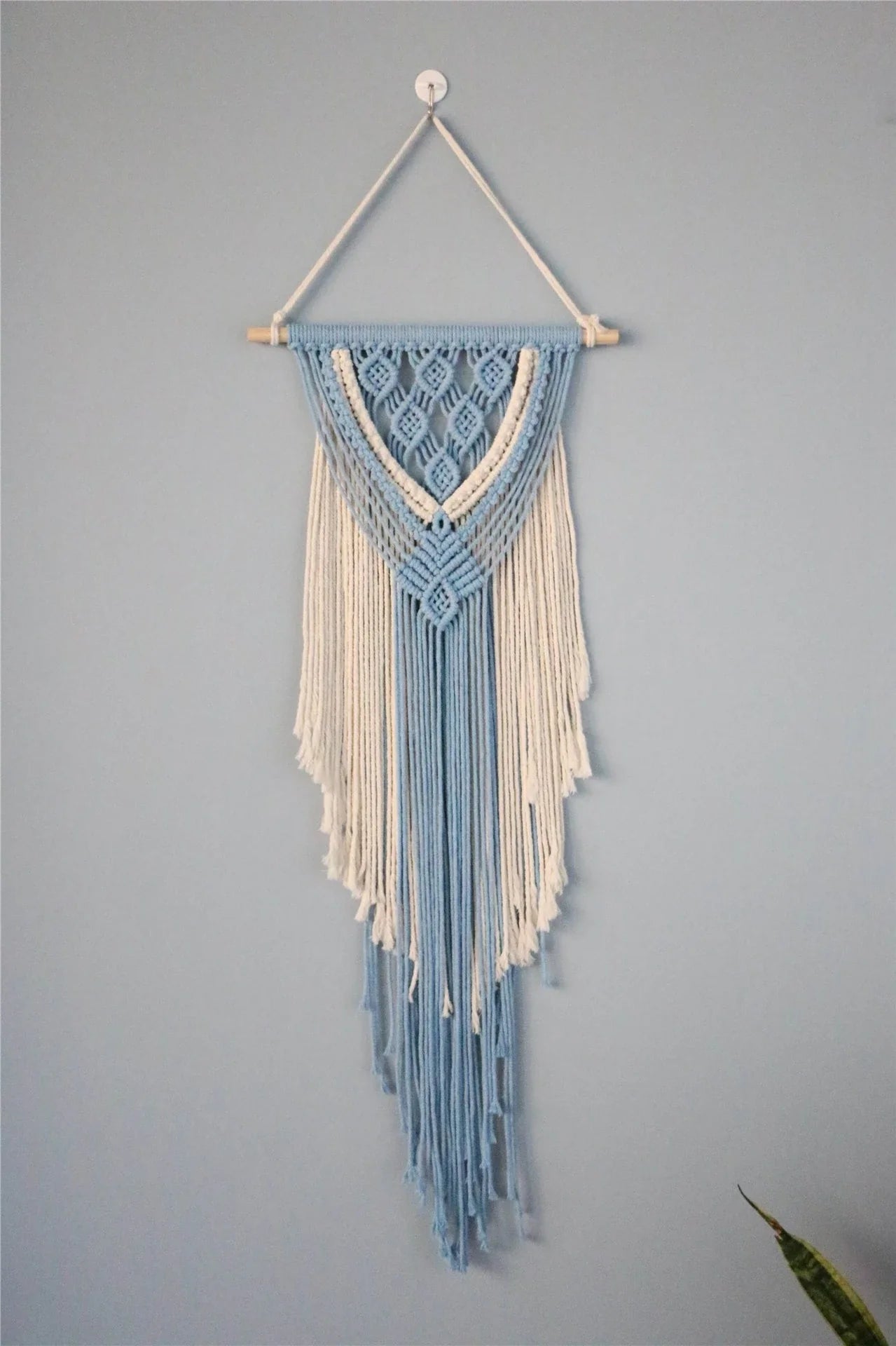 Hand-woven cotton string tapestry with blue and white colours, featuring playful tassels for a modern and rustic wall decoration