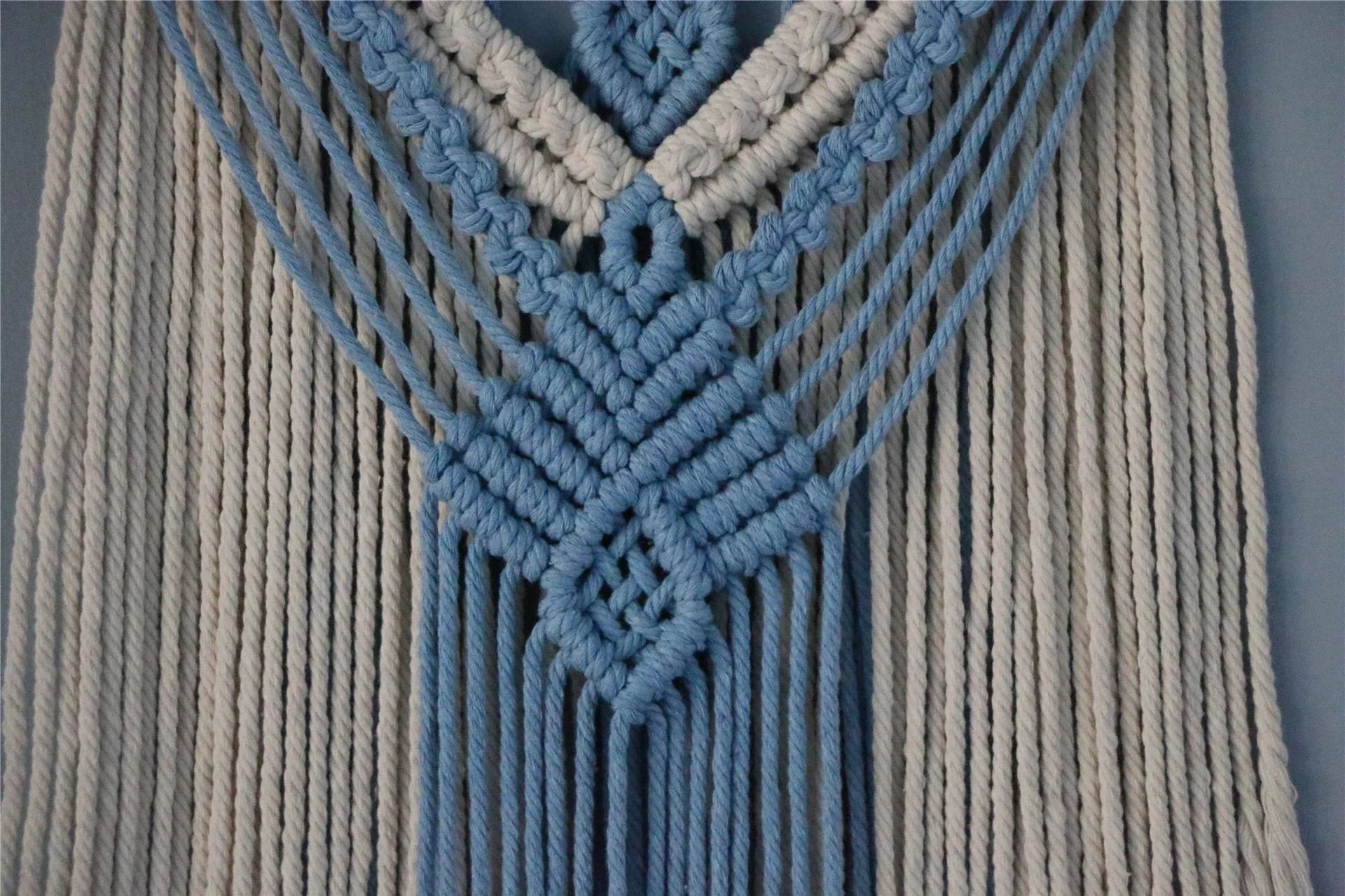Hand-woven cotton string tapestry with blue and white colours, featuring playful tassels for a modern and rustic wall decoration