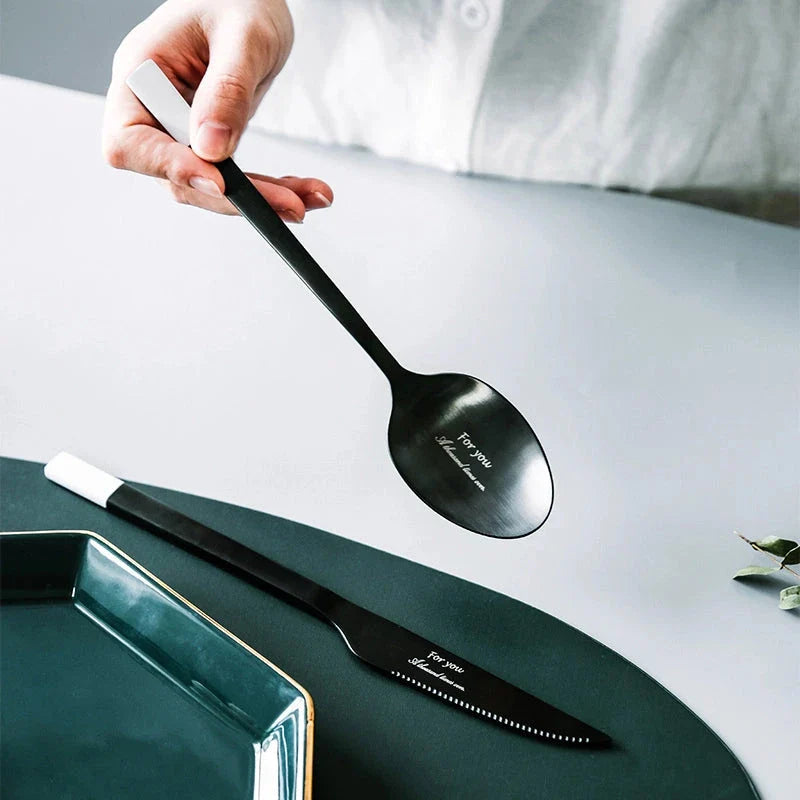 Elegant Nordic Stainless Steel Cutlery Set with a sleek black and white design, including knife, fork, spoon, and chopsticks