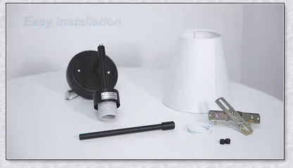A modern, black and white wireless wall lamp with a fabric shade, providing elegant lighting for a living room or bedroom.