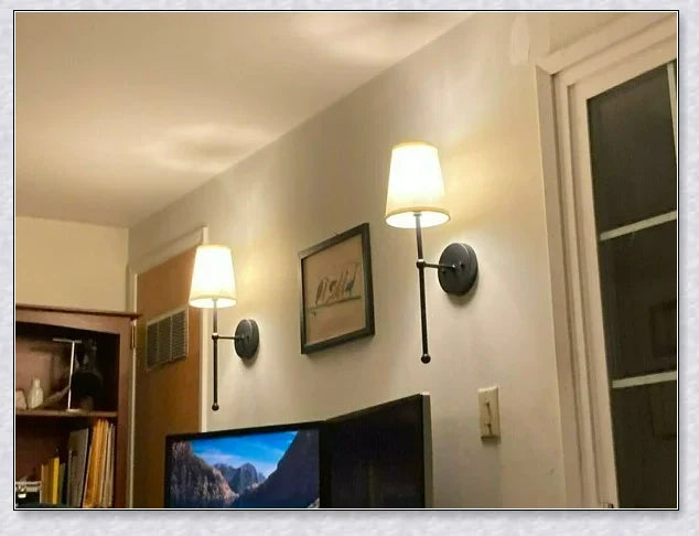 A modern, black and white wireless wall lamp with a fabric shade, providing elegant lighting for a living room or bedroom.