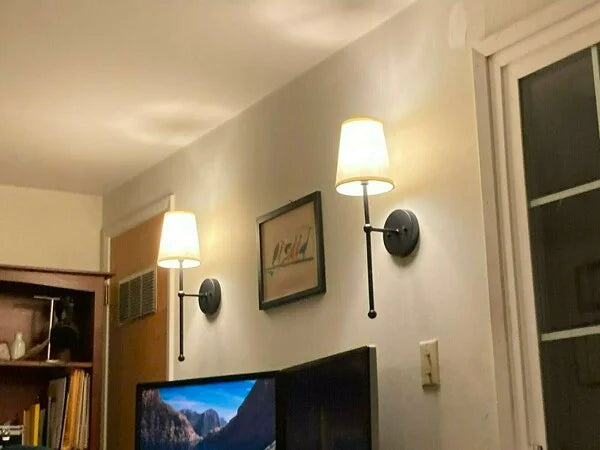 A modern, black and white wireless wall lamp with a fabric shade, providing elegant lighting for a living room or bedroom.