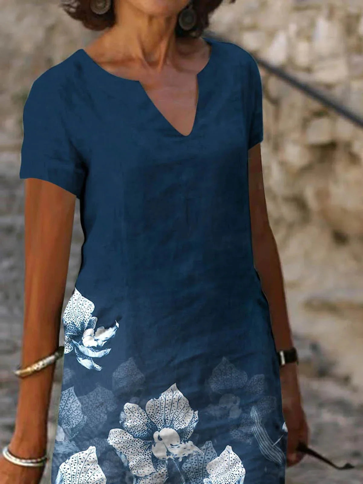 A floral printed midi dress made from a cotton-linen blend fabric, featuring a V-neck and short sleeves.
