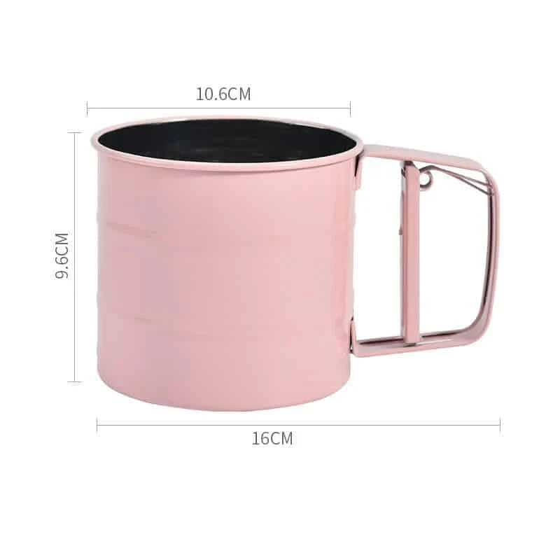 Stainless steel handheld baking flour sifter in a soft pink colour, designed for efficient sifting and aeration of dry ingredients for light and fluffy baked goods.