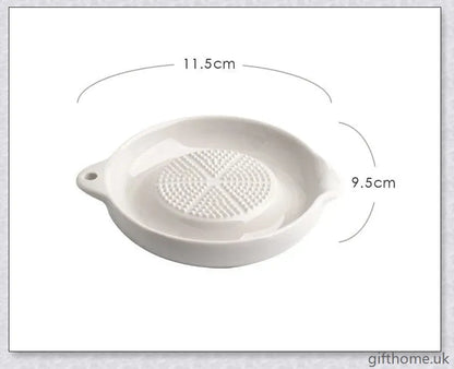 A white ceramic ginger grater, a safe and convenient kitchen tool for grating, mincing, and shredding a variety of ingredients.