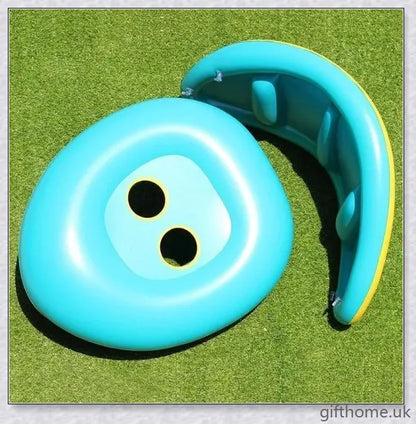 A baby swimming in a blue and white clamshell-style inflatable swimming pool float with a sun canopy and steering wheel