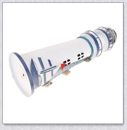 Oceanica LED Lighthouse Lantern Nightlight with nautical details like a small boat, life buoy, and seashells, providing a soft warm glow.