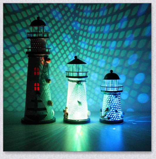 Oceanica LED Lighthouse Lantern Nightlight with nautical details like a small boat, life buoy, and seashells, providing a soft warm glow.