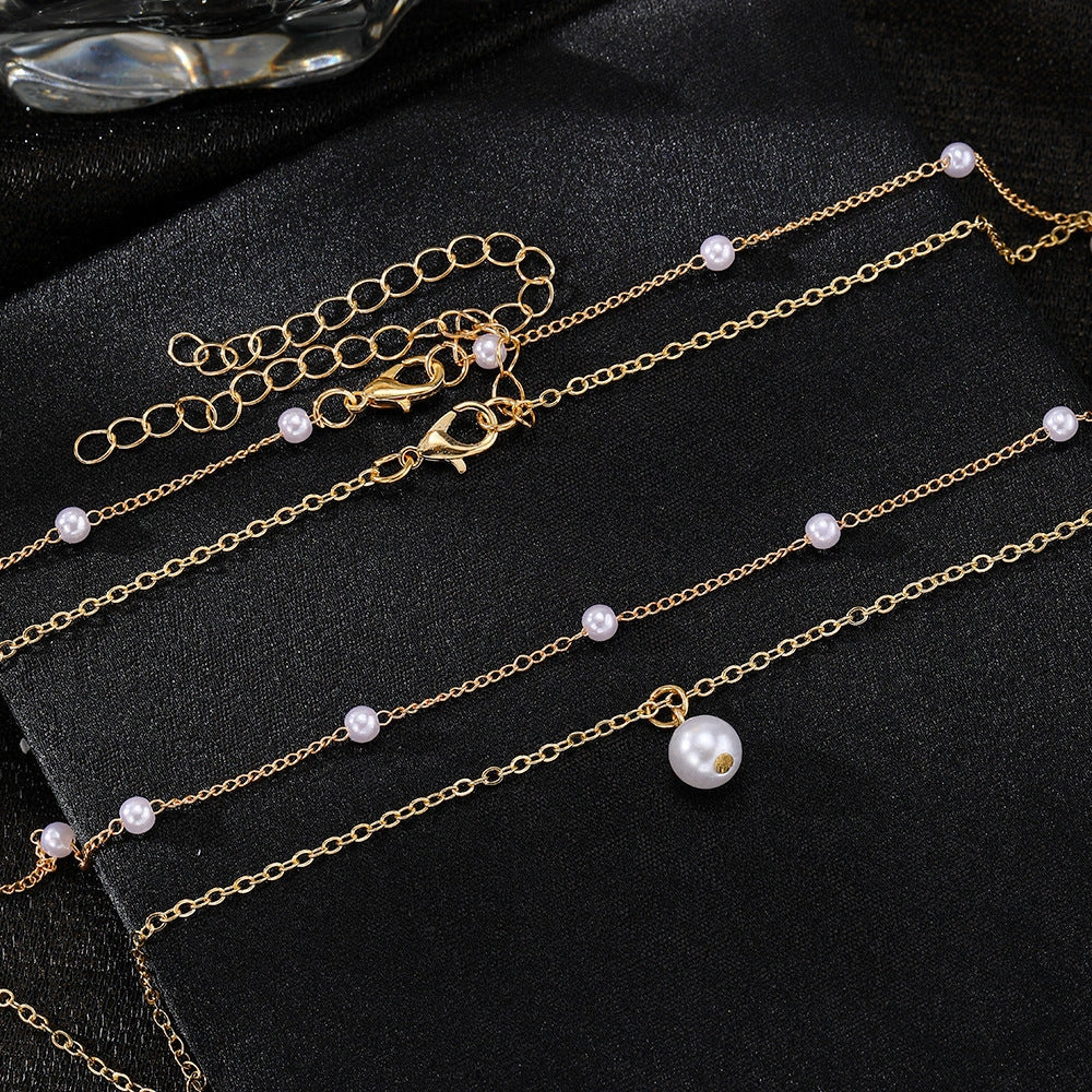 Elegant pearl and tassel double-layer necklace in gold tone, a timeless accessory for discerning women