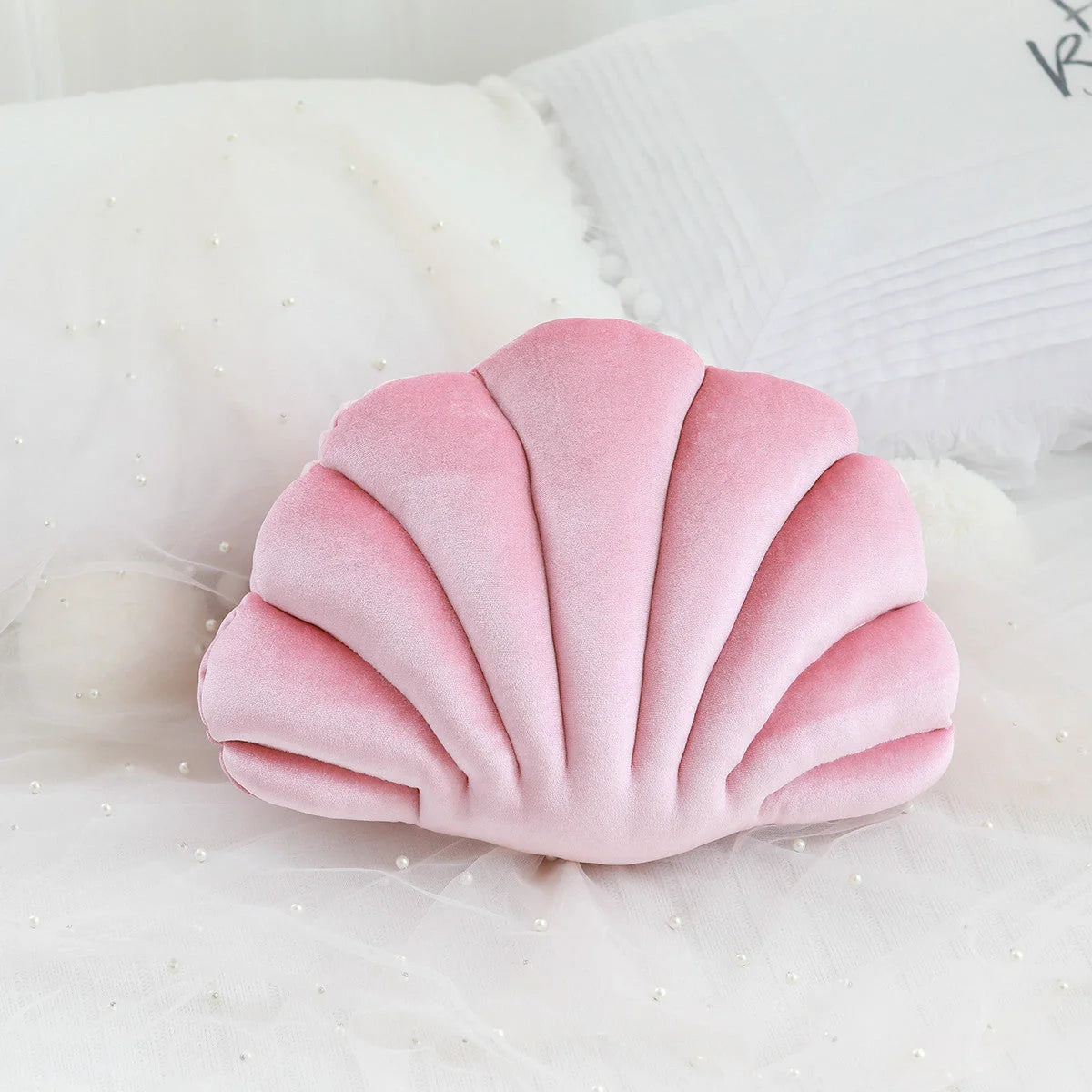 Cosy shell-shaped plush nap pillow in various colours and sizes for ultimate comfort