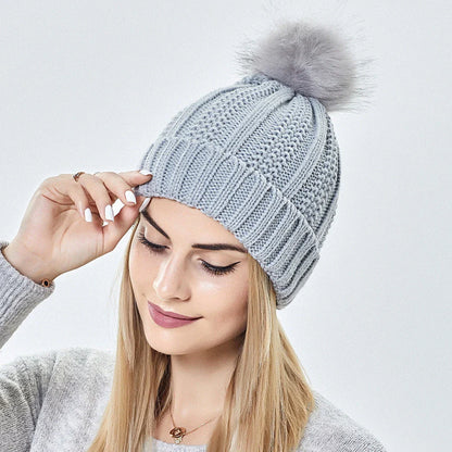 Stylish knit beanie with satin lining and faux fur pom-pom for women, available in multiple color options