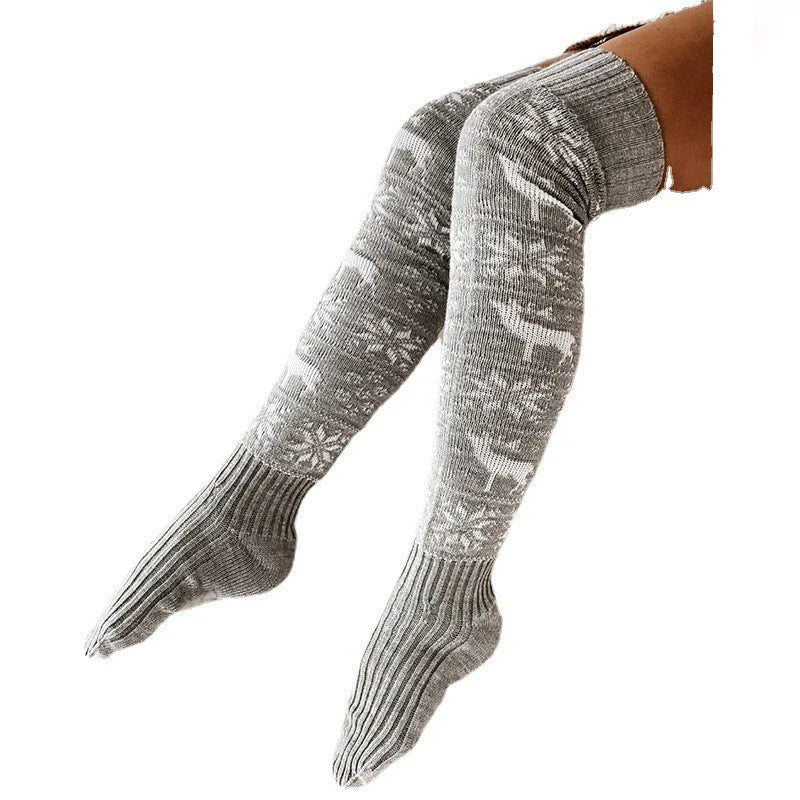 Cozy Christmas knee-high socks for women featuring a festive snowflake and reindeer pattern, designed to provide warmth and comfort during the winter season.