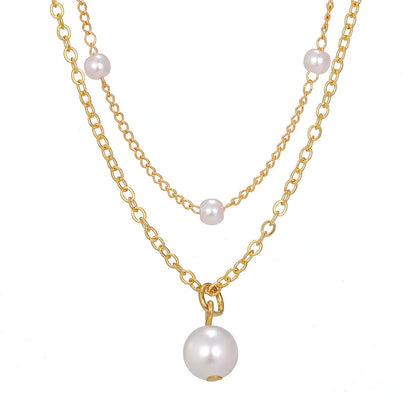Elegant pearl and tassel double-layer necklace in gold tone, a timeless accessory for discerning women