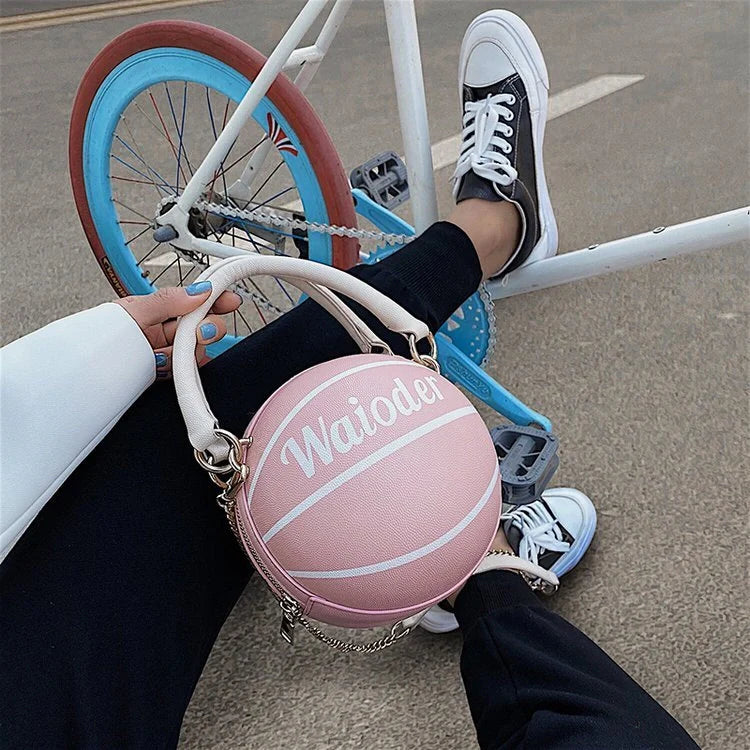 Basketball-shaped handbag in pink, white, black, or brown with adjustable chain shoulder strap