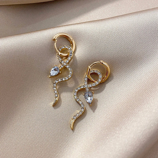 Elegant gold-toned snake charm earrings with a dangle design, perfect for adding a touch of sophistication to any outfit.