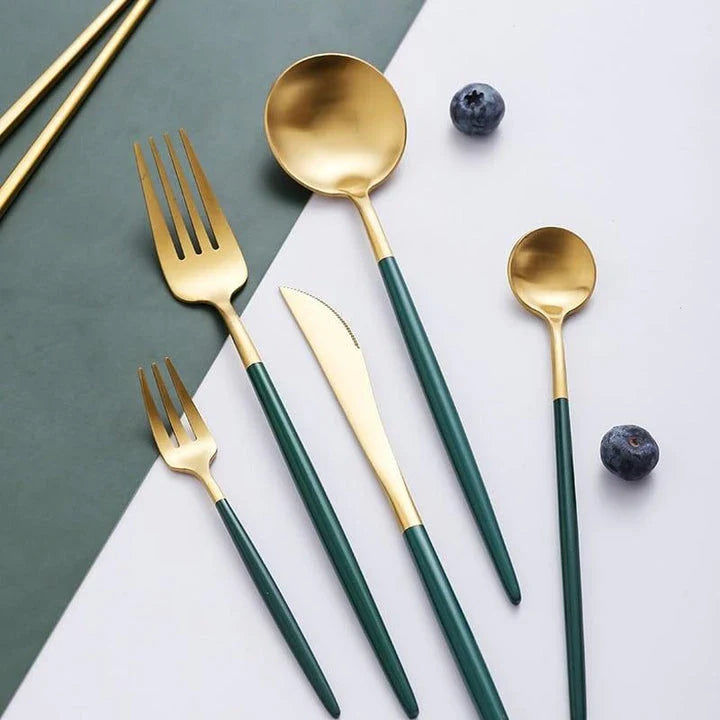 A set of minimalist, eco-friendly tableware in green and gold tones, including plates, bowls, and utensils.