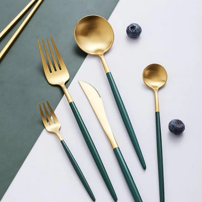 A set of minimalist, eco-friendly tableware in green and gold tones, including plates, bowls, and utensils.