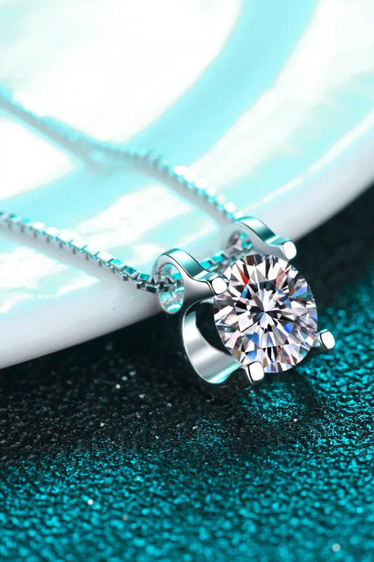 Closeup view of a sparkling 1 carat moissanite gemstone set in a rhodium-plated 925 sterling silver chain necklace