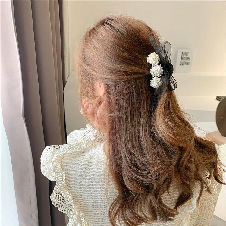 Korean pearl bow hair clip in black, alloy construction for durability and style.