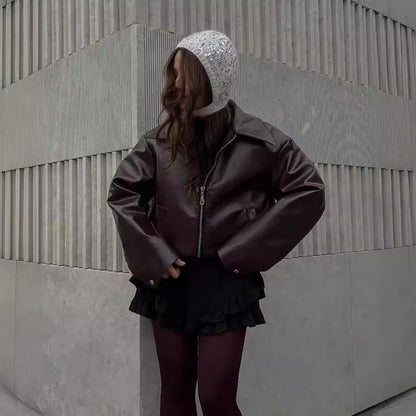 Fashionable faux leather jacket in burgundy and black colors, featuring a zipper closure and long sleeves for casual, versatile wear