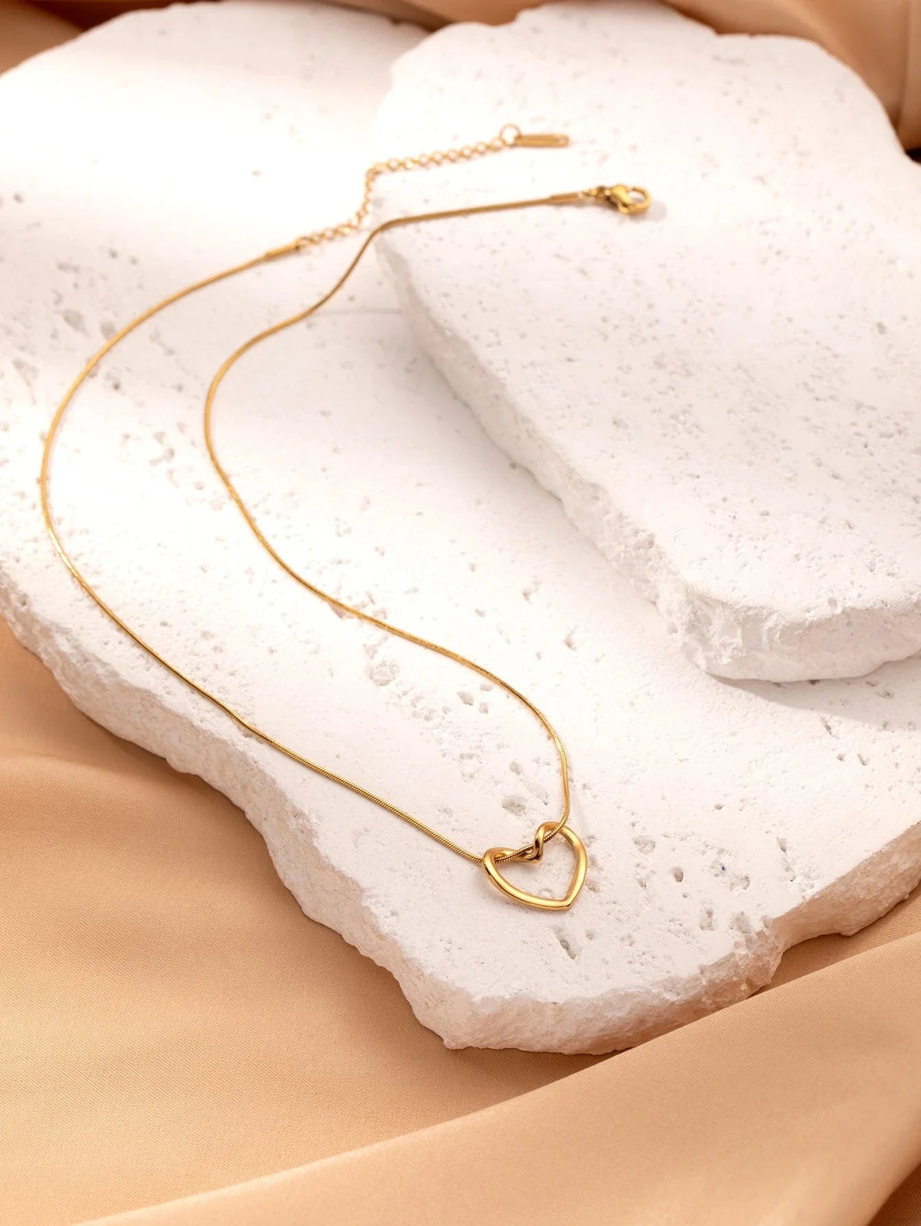 Titanium steel heart pendant necklace in gold and silver finishes, featuring an elegant and adjustable design for a customized fit