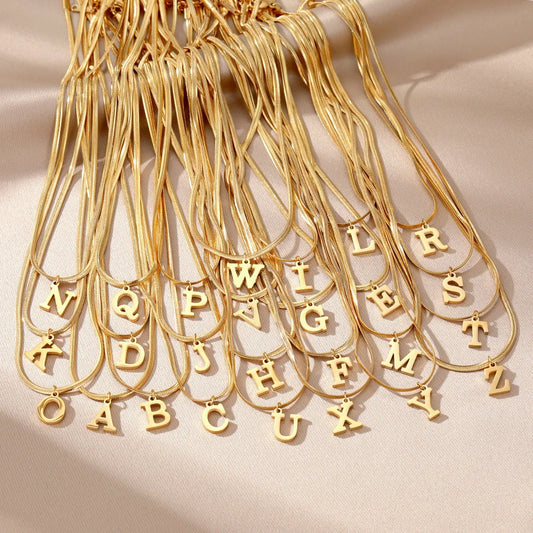 Gold-coloured A-Z letter pendant necklace on a snake chain
