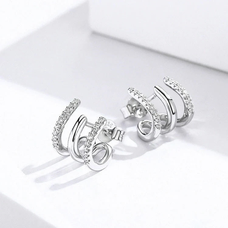 Elegant three-layer sterling silver heart earrings with sparkling gems, perfect for any occasion.