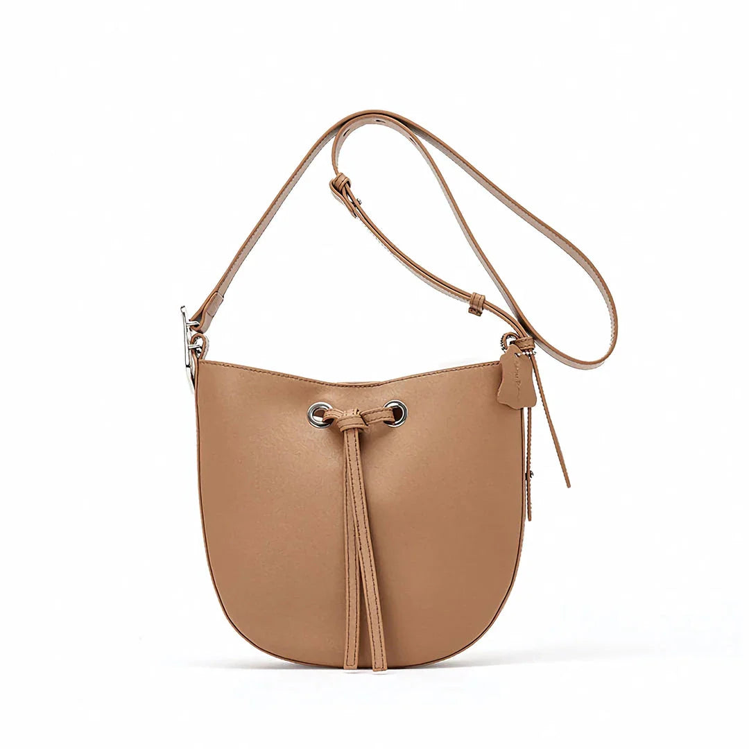 Elegant black leather bucket handbag with a metal buckle detail and adjustable strap