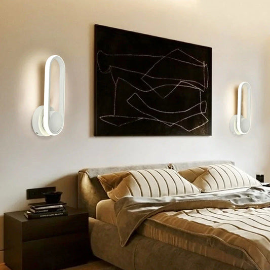 A modern bedside reading wall light with a sleek metal frame and adjustable acrylic shade, providing customisable ambient lighting for a British bedroom.