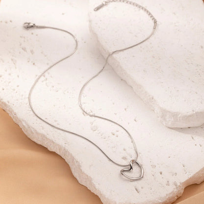 Titanium steel heart pendant necklace in gold and silver finishes, featuring an elegant and adjustable design for a customized fit